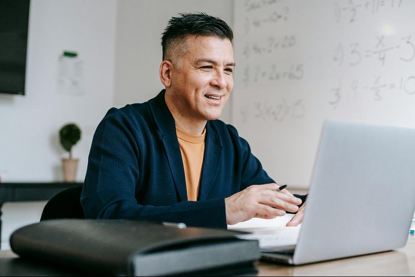 A Kiin user working at a desk with equations on a board